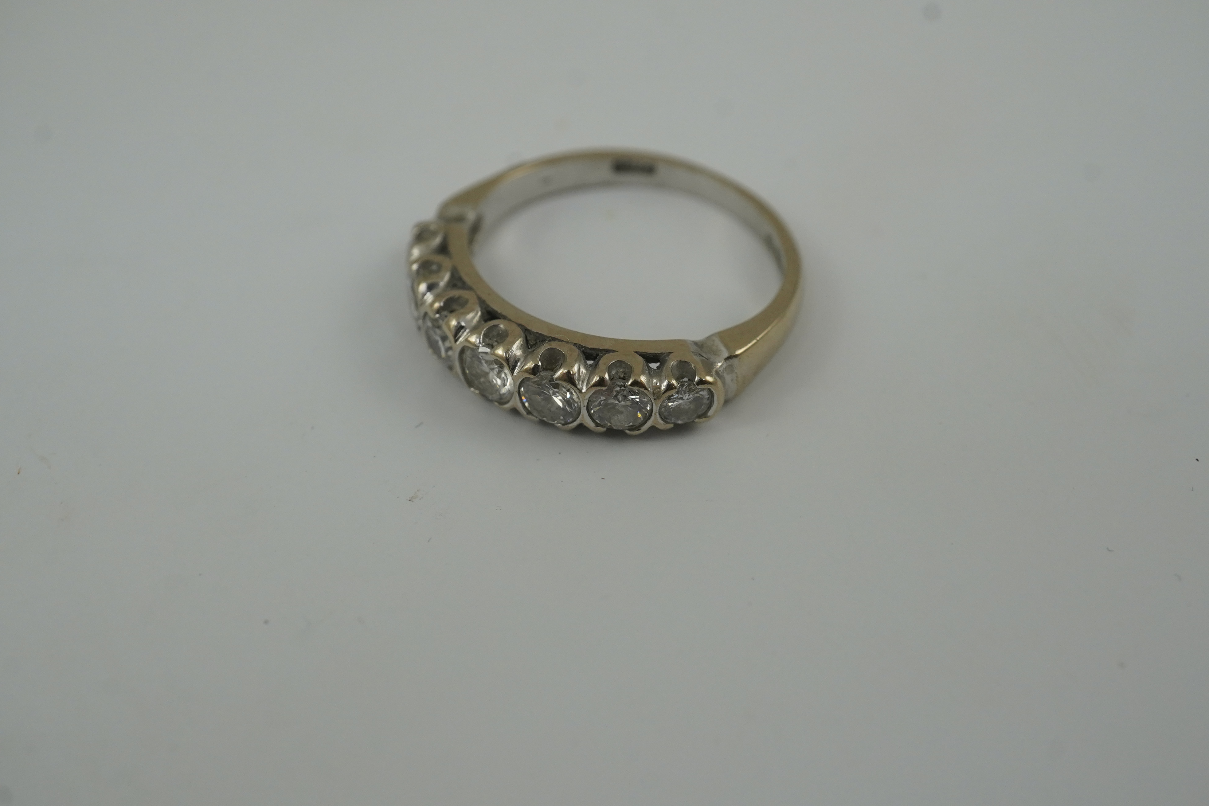 A modern 18ct white gold and graduated seven stone diamond set half hoop ring